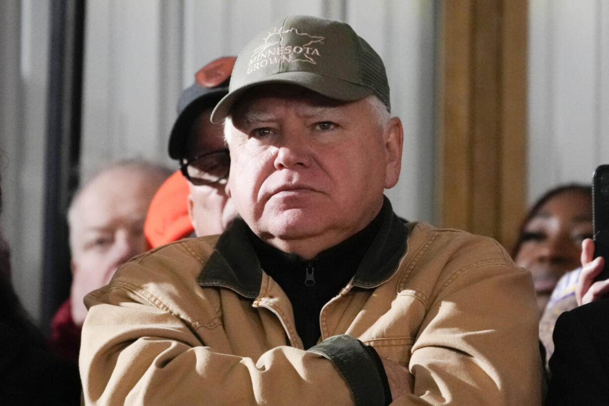 FILE - Minnesota Gov. Tim Walz listens as President Joe Biden speaks at Dutch Creek Farms in Northfield, Minn., Nov. 1, 2023.