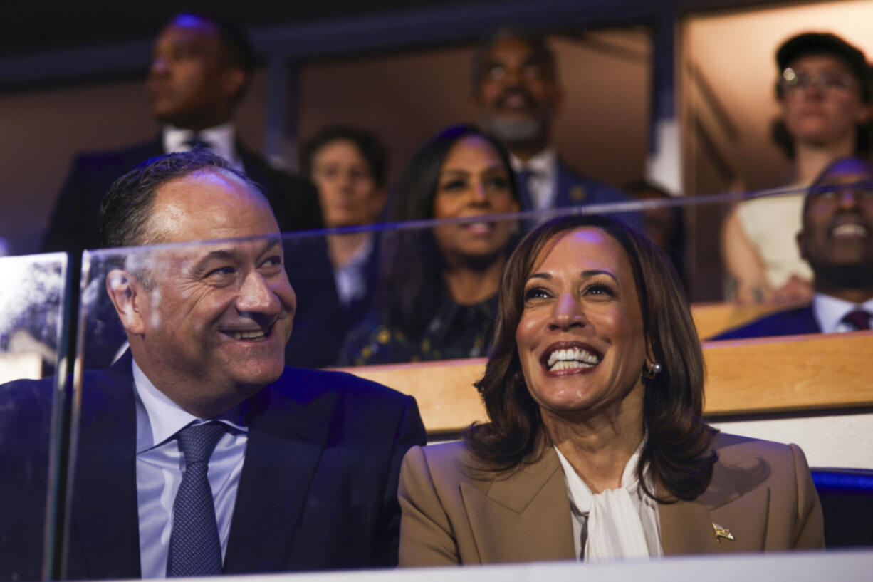 Second gentleman Doug Emhoff, left, and Democratic presidential nominee Vice President Kamala Harris listen during speeches at the Democratic National Convention, Monday, Aug. 19, 2024, in Chicago.