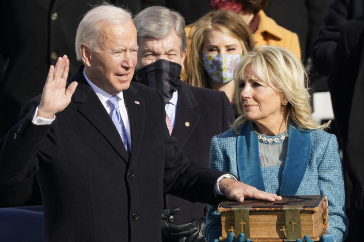 FILE - Joe Biden is sworn in as the 46th president of the United States by Chief Justice John Roberts as Jill Biden holds the Bible during the 59th Presidential Inauguration at the U.S. Capitol in Washington, Jan. 20, 2021.