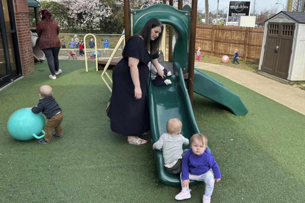 FILE - Delaney Griffin, center, plays with toddlers at the child care center where she works, March 13, 2024, in Lexington, Ky.