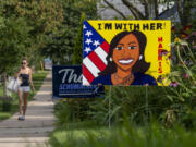 A pedestrian walks along the sidewalk past a sign in support of Kamal Harris on Tuesday, July 30, 2024, in Madison, Wis.