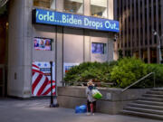 FILE - A passerby watches a news crawl appears on the side of the Fox News building in New York, Sunday, July 21, 2024, in the wake of President Joe Biden dropping out of the presidential race. Biden&rsquo;s announcement was a startling example of how fast and how far word spreads in today&rsquo;s always-connected world.