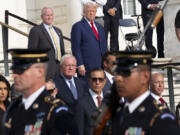 Bob Quackenbush, top left, deputy chief of staff for Arlington National Cemetery, and Republican presidential nominee former President Donald Trump watch the changing of the guard at the Tomb of the Unknown Solider at Arlington National Cemetery, Monday, Aug. 26, 2024, in Arlington, Va.