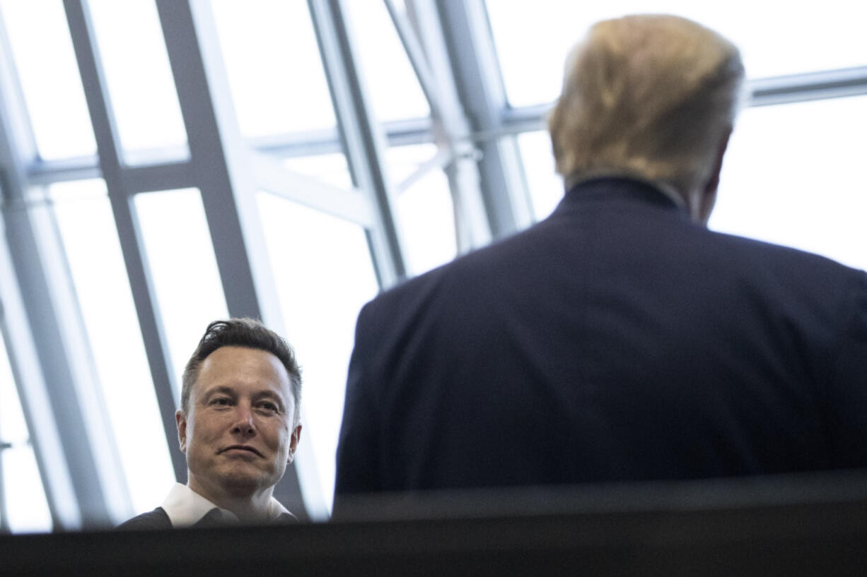 FILE - Tesla and SpaceX CEO Elon Musk talks with President Donald Trump, May 30, 2020, in Cape Canaveral, Fla.