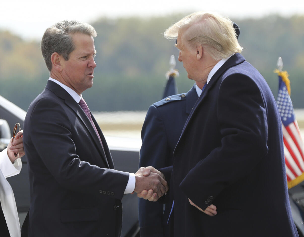 FILE - Georgia Gov. Brian Kemp, left, greets President Donald Trump as he arrives at Dobbins Air Reserve Base, Nov. 8, 2019, in Marietta, Ga.