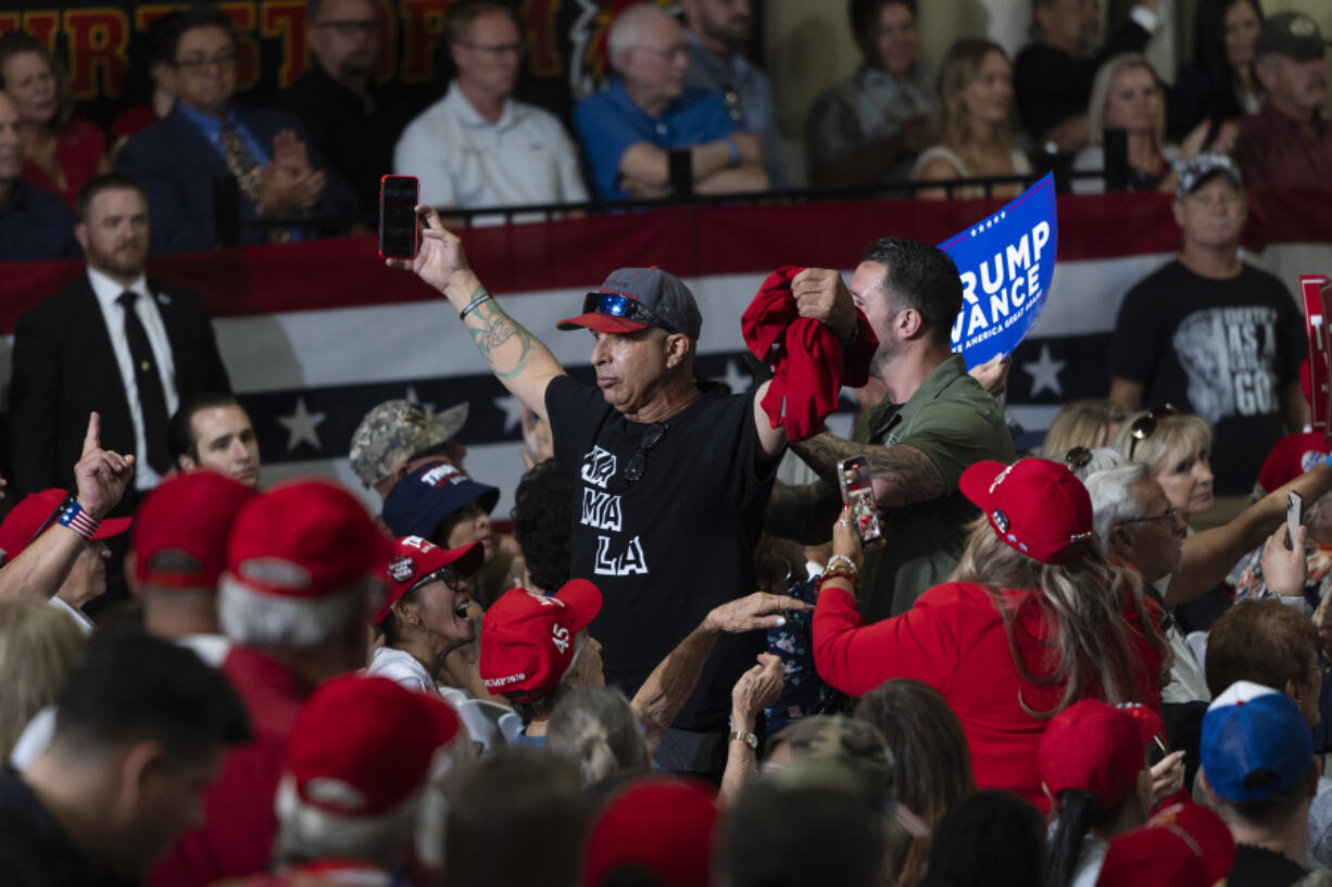 A heckler wearing a T-shirt bearing the name of Vice President Kamala Harris is escorted off a campaign event with Republican vice presidential candidate Sen. JD Vance, R-Ohio, in Glendale, Ariz., Wednesday, July 31, 2024. (AP Photo/Jae C.