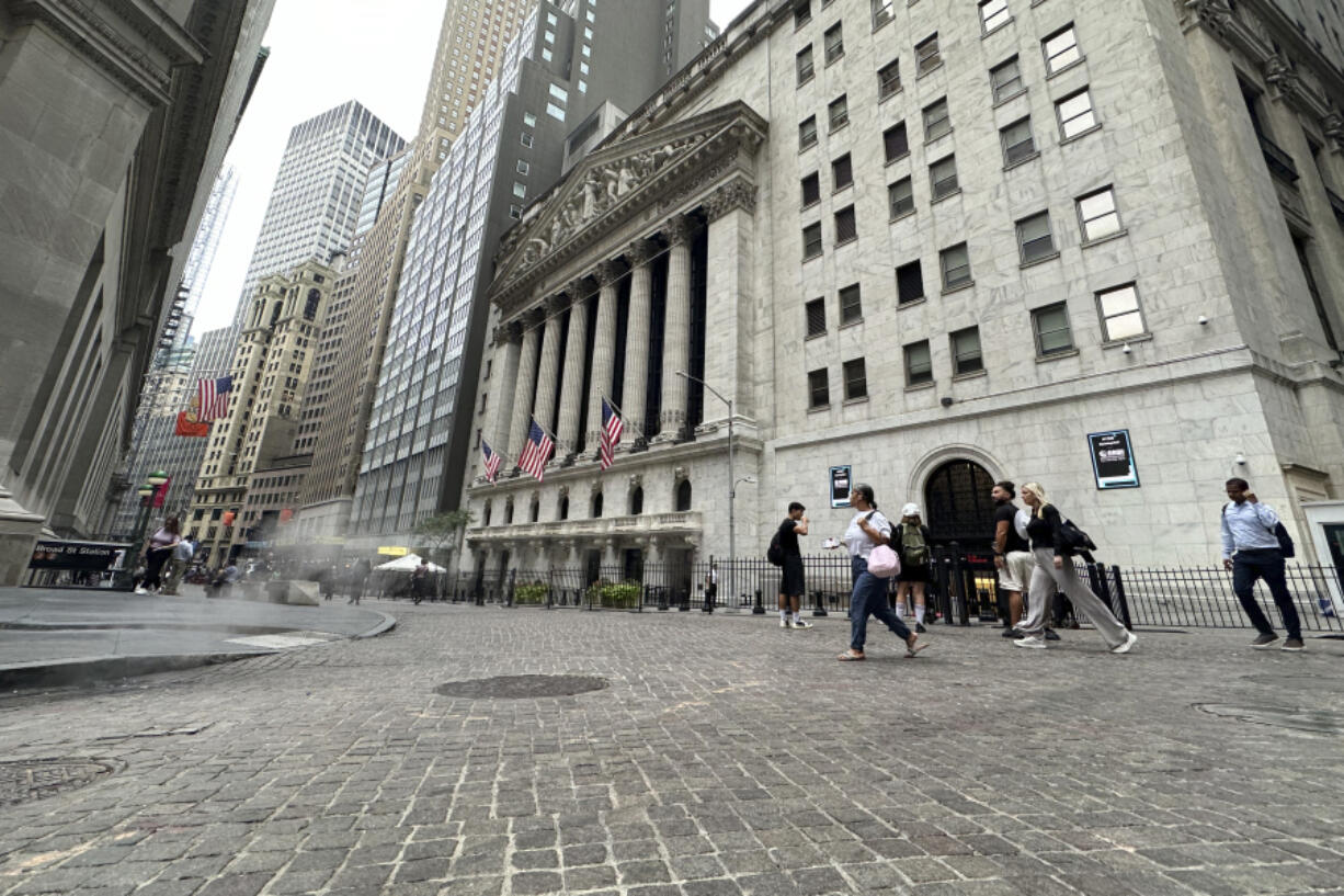 FILE - People pass the New York Stock Exchange on July 31, 2024 in New York. World shares have tumbled on Friday, August 2, 2024, with Japan&rsquo;s Nikkei 225 index slumping 5.8% as investors panicked over signs of weakness in the U.S.