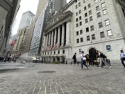 FILE - People pass the New York Stock Exchange on July 31, 2024 in New York. World shares have tumbled on Friday, August 2, 2024, with Japan&rsquo;s Nikkei 225 index slumping 5.8% as investors panicked over signs of weakness in the U.S.