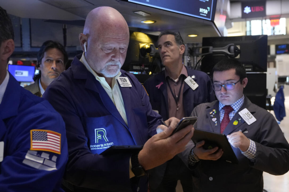 FILE - Robert Moran, left, works with fellow traders on the floor of the New York Stock Exchange, Friday, Aug. 16, 2024.