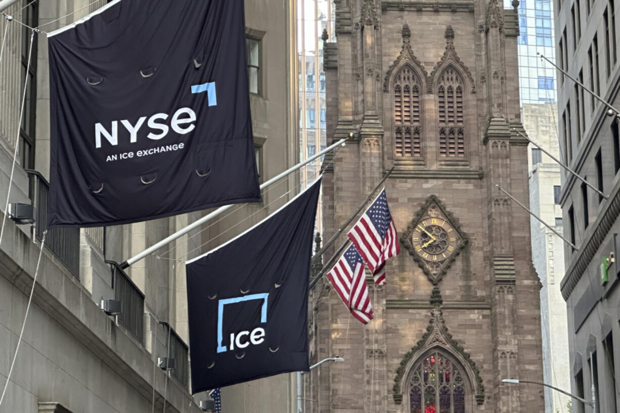 Flags fly on the side of the New York Stock Exchange with Trinity Church in the background on Wednesday, Aug. 28, 2024, in New York.