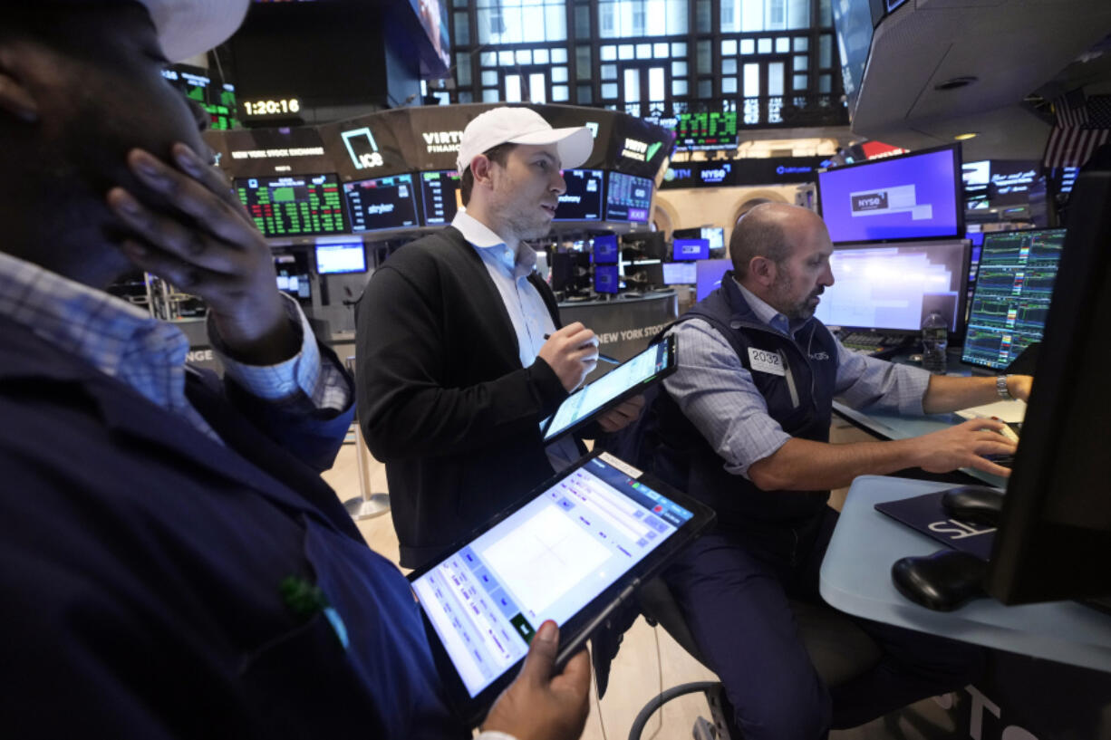 A pair of traders work at the post of specialist James Denaro, right, on the floor of the New York Stock Exchange, Wednesday, July 31, 2024.