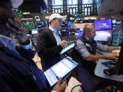 A pair of traders work at the post of specialist James Denaro, right, on the floor of the New York Stock Exchange, Wednesday, July 31, 2024.