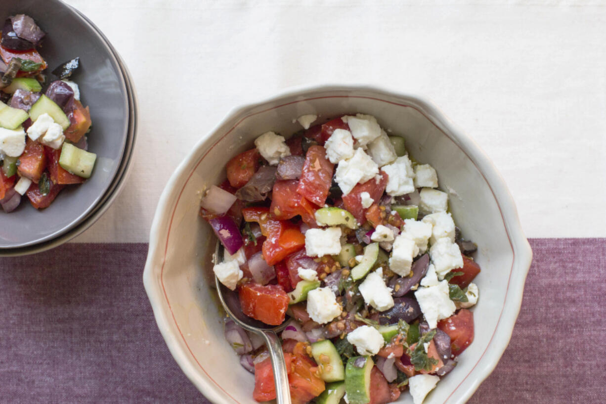 Traditional Greek salad with fresh cucumbers, tomatoes, feta, onion, and olives.