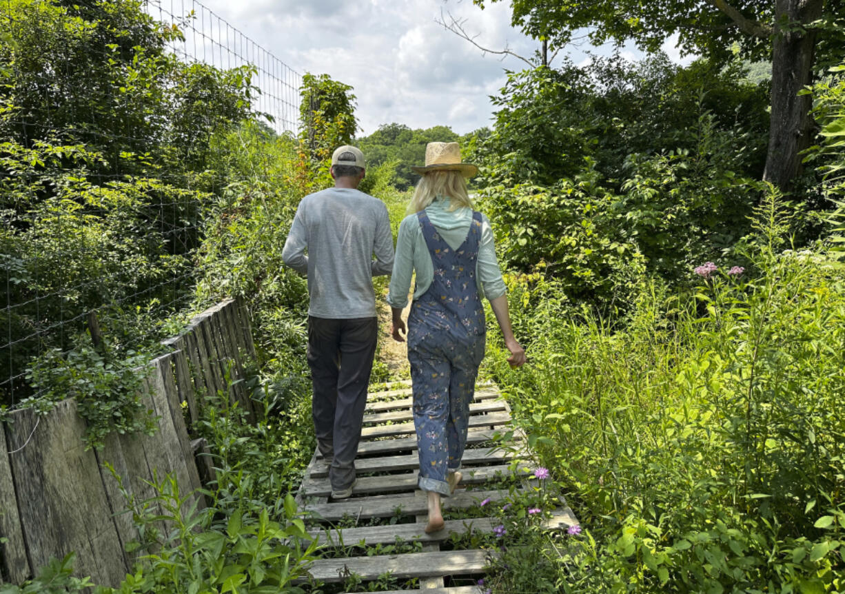 The founders of Fruition Seeds, Matthew Goldfarb, left, and Petra Page-Mann, walk on their farm Aug. 1 in Naples, N.Y. The multimillion-dollar organic seed company has declared that &ldquo;seeds are gifts&rdquo; and will be giving them away after this month.