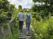 The founders of Fruition Seeds, Matthew Goldfarb, left, and Petra Page-Mann, walk on their farm Aug. 1 in Naples, N.Y. The multimillion-dollar organic seed company has declared that &ldquo;seeds are gifts&rdquo; and will be giving them away after this month.