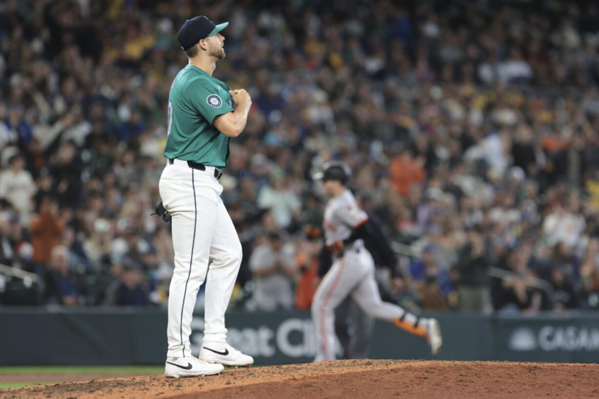 Seattle Mariners pitcher Austin Voth, left, walks to the mound after giving up a home run to San Francisco Giants Mike Yastrzemski, right, during the seventh inning of a baseball game, Saturday, Aug. 24, 2024, in Seattle.