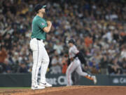 Seattle Mariners pitcher Austin Voth, left, walks to the mound after giving up a home run to San Francisco Giants Mike Yastrzemski, right, during the seventh inning of a baseball game, Saturday, Aug. 24, 2024, in Seattle.