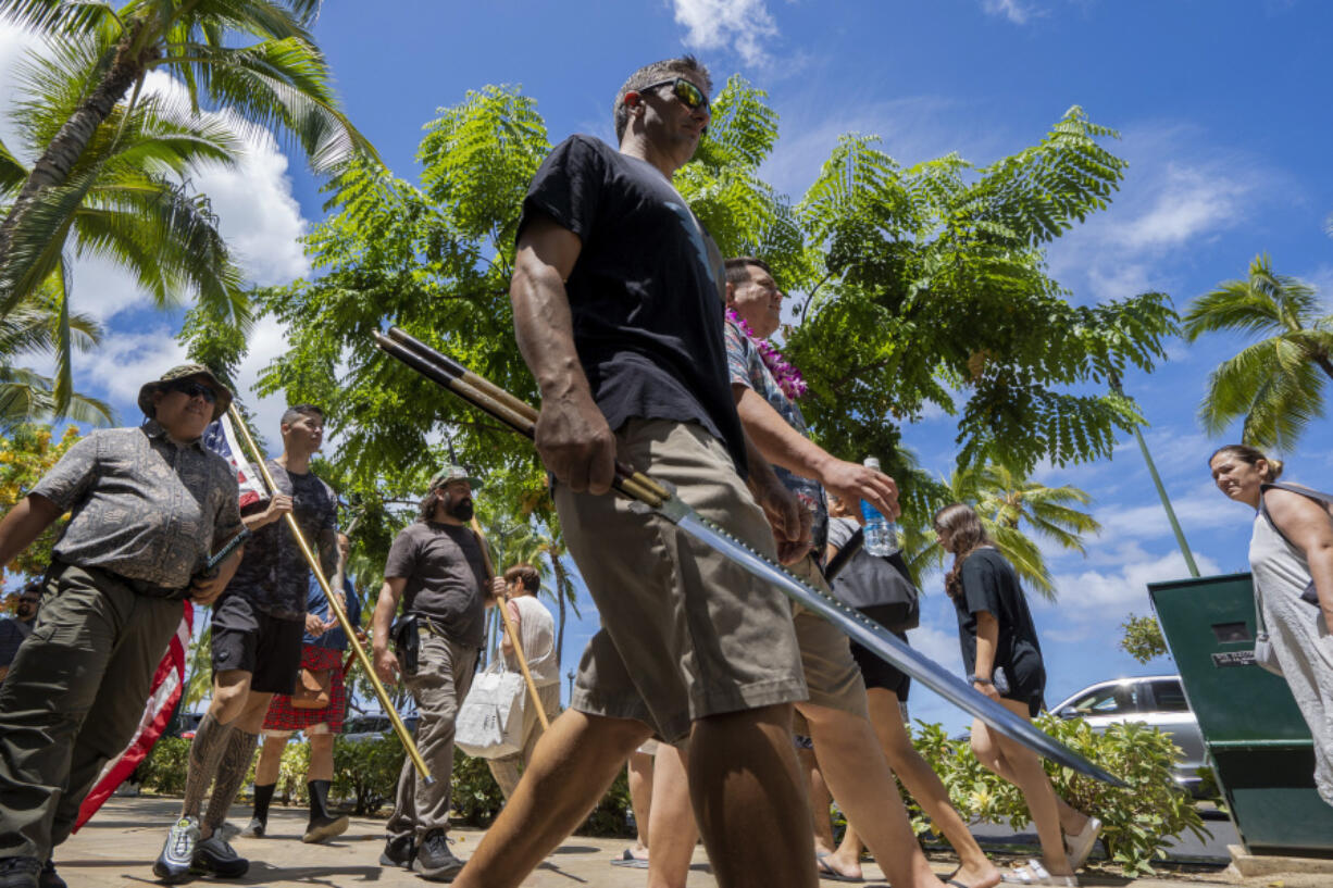 Members of Hawaii Firearms Coalition walk around Waikiki with their non-firearm weapons on Saturday, June 22, 2024, in Honolulu, Hawaii.