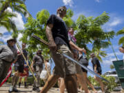 Members of Hawaii Firearms Coalition walk around Waikiki with their non-firearm weapons on Saturday, June 22, 2024, in Honolulu, Hawaii.