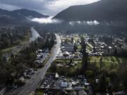 FILE - Vehicles drive down Rogue River Highway as light shines on the area on Saturday, March 23, 2024, in Grants Pass, Ore. The small Oregon city at the heart of a recent U.S. Supreme Court ruling on outdoor sleeping bans has voted to prohibit camping but establish certain areas where homeless people can go.