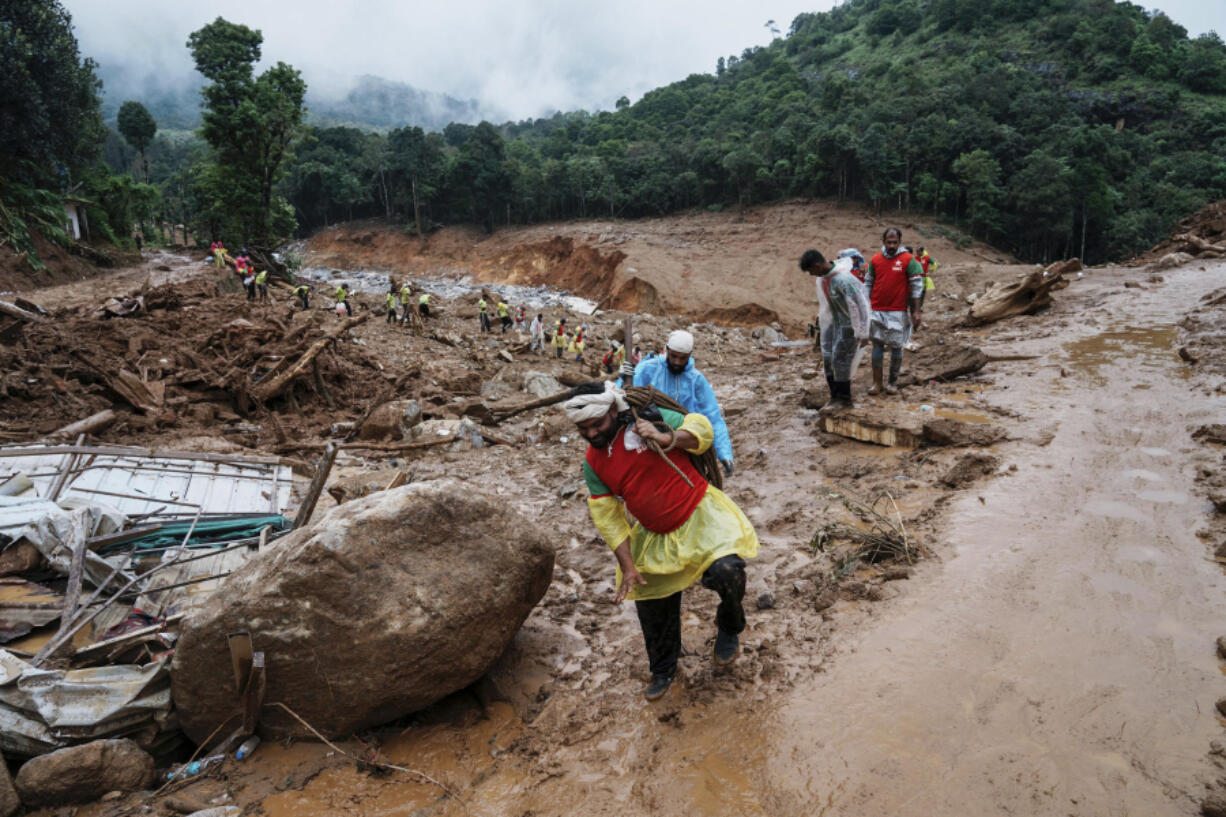 Rescuers make their way to the upper regions as they search through mud and debris for a third day after landslides set off by torrential rains in Wayanad district, Kerala state, India, Thursday, Aug. 1, 2024.