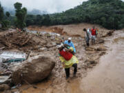 Rescuers make their way to the upper regions as they search through mud and debris for a third day after landslides set off by torrential rains in Wayanad district, Kerala state, India, Thursday, Aug. 1, 2024.