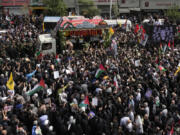 Iranians follow the truck carrying the coffins of Hamas leader Ismail Haniyeh and his bodyguard who were killed in an assassination blamed on Israel on Wednesday, during their funeral ceremony at Enqelab-e-Eslami (Islamic Revolution) Sq. in Tehran, Iran, Thursday, Aug. 1, 2024.