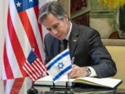 FILE - U.S. Secretary of State Antony Blinken signs a guest book before his meeting with Israel&rsquo;s President Isaac Herzog at the Presidency, Sunday, March 27, 2022, in Jerusalem.