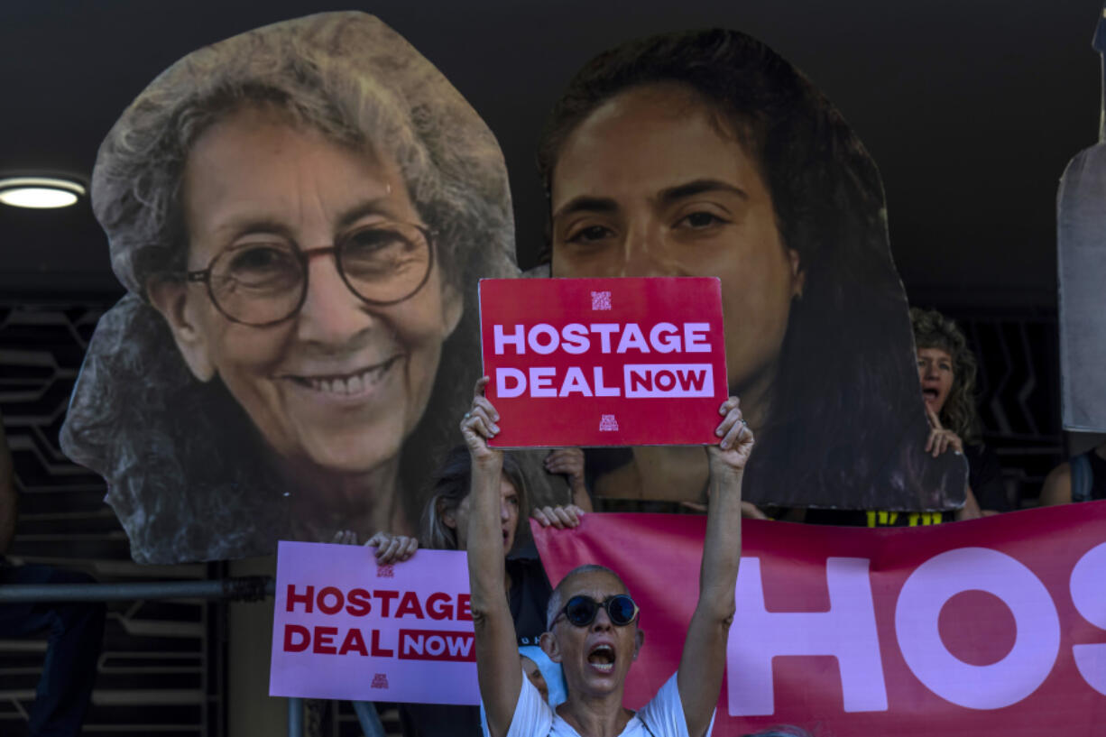 Relatives and supporters of Israeli hostages held by Hamas in Gaza hold photos of their loved ones during a protest calling for their return in Tel Aviv, Israel, Thursday, Aug. 15, 2024.