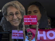 Relatives and supporters of Israeli hostages held by Hamas in Gaza hold photos of their loved ones during a protest calling for their return in Tel Aviv, Israel, Thursday, Aug. 15, 2024.