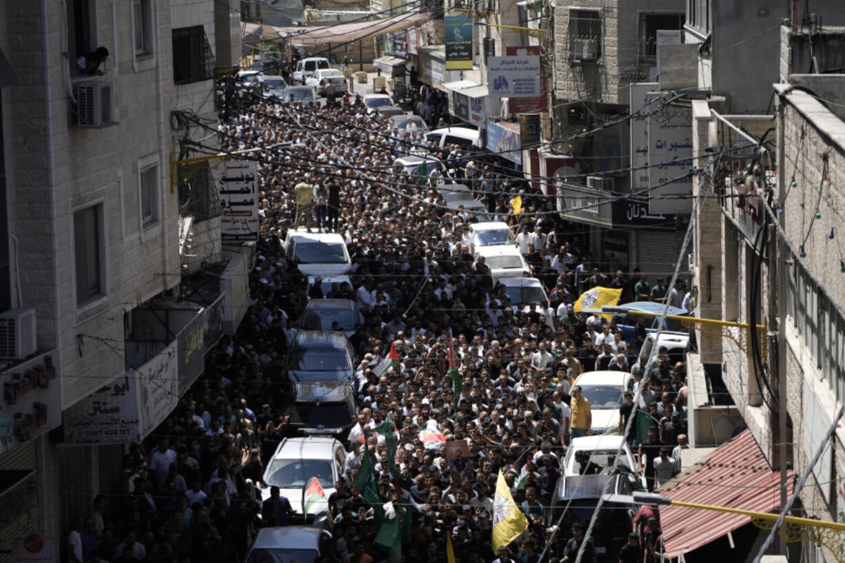 Mourners carry the body of Mahmoud Haroub, 18, during his funeral the day after he was killed in clashes with Israeli forces in the West Bank town of Dura, near Hebron, according to the Palestinian Ministry of Health, Tuesday, Aug. 20, 2024.