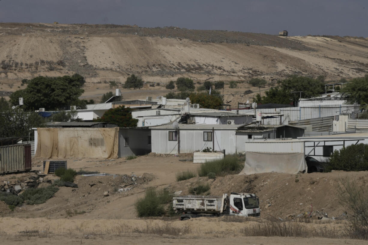 Houses of Bedouin families stand on area in the Negev desert next to a place where relatives and friends of Qaid Farhan Alkadi, 52, who was held hostage by Hamas militants in Gaza Strip, wait for his arrival in the Khirbet Karkur village, near Rahat, southern Israel, Wednesday, Aug. 28, 2024.