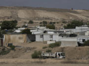 Houses of Bedouin families stand on area in the Negev desert next to a place where relatives and friends of Qaid Farhan Alkadi, 52, who was held hostage by Hamas militants in Gaza Strip, wait for his arrival in the Khirbet Karkur village, near Rahat, southern Israel, Wednesday, Aug. 28, 2024.