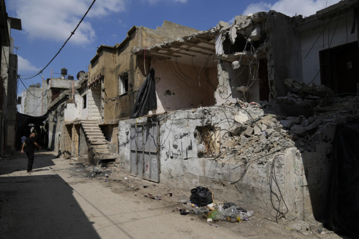 A Palestinian man inspects damaged houses following an Israeli military operation in the West Bank refugee camp of Nur Shams, Tulkarem Friday, Aug. 30, 2024.