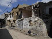 A Palestinian man inspects damaged houses following an Israeli military operation in the West Bank refugee camp of Nur Shams, Tulkarem Friday, Aug. 30, 2024.