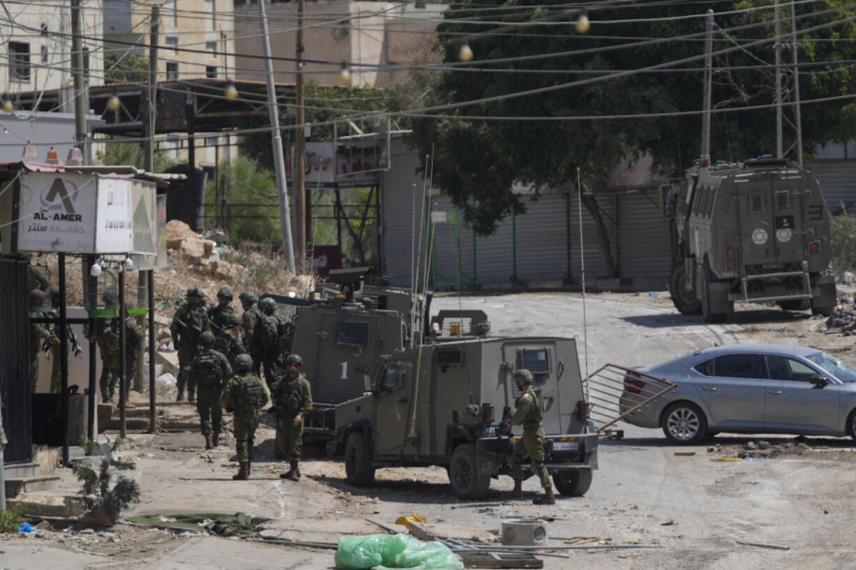 Members of Israeli forces patrol a street during a military operation in the West Bank refugee camp of Al-Faraa, Wednesday, Aug. 28, 2024.