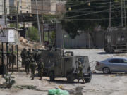 Members of Israeli forces patrol a street during a military operation in the West Bank refugee camp of Al-Faraa, Wednesday, Aug. 28, 2024.