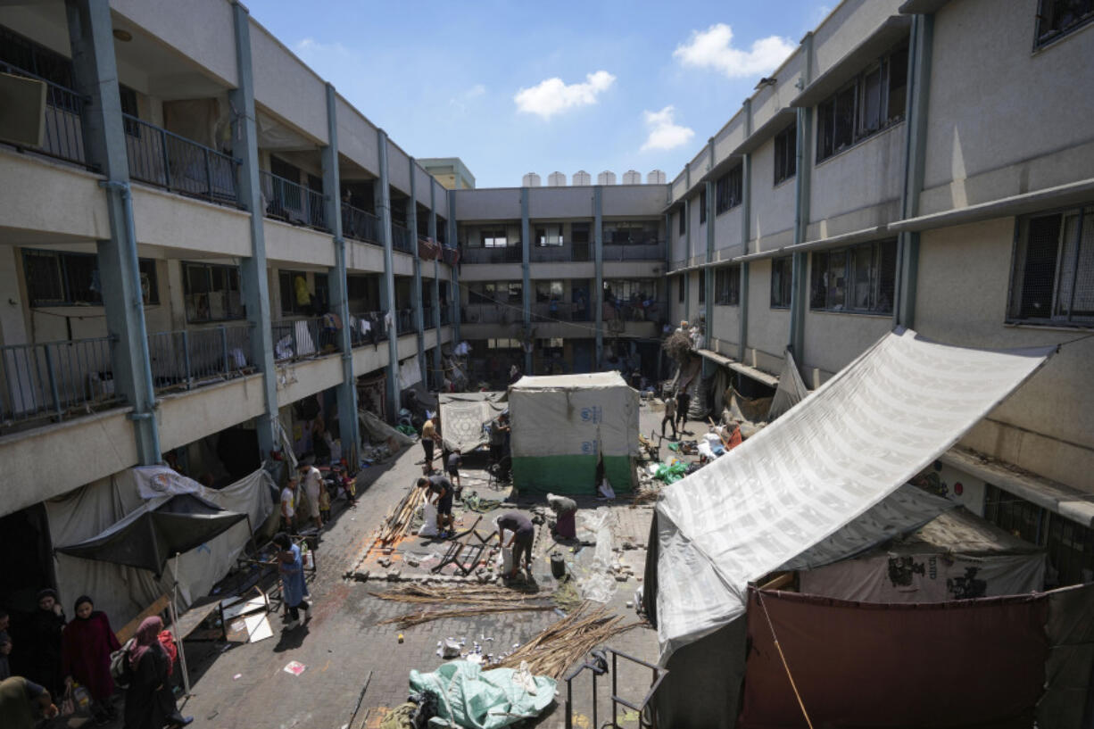 Palestinians tear down a tent as they evacuate a school that had been their shelter, in eastern Deir al-Balah, Gaza Strip, Friday, Aug. 16, 2024, after the Israeli military dropped leaflets asking civilians to evacuate from the area and northern Khan Younis, saying forces plan to respond to rocket fire that targeted Israel.