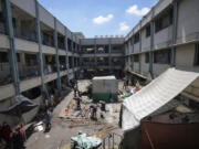 Palestinians tear down a tent as they evacuate a school that had been their shelter, in eastern Deir al-Balah, Gaza Strip, Friday, Aug. 16, 2024, after the Israeli military dropped leaflets asking civilians to evacuate from the area and northern Khan Younis, saying forces plan to respond to rocket fire that targeted Israel.