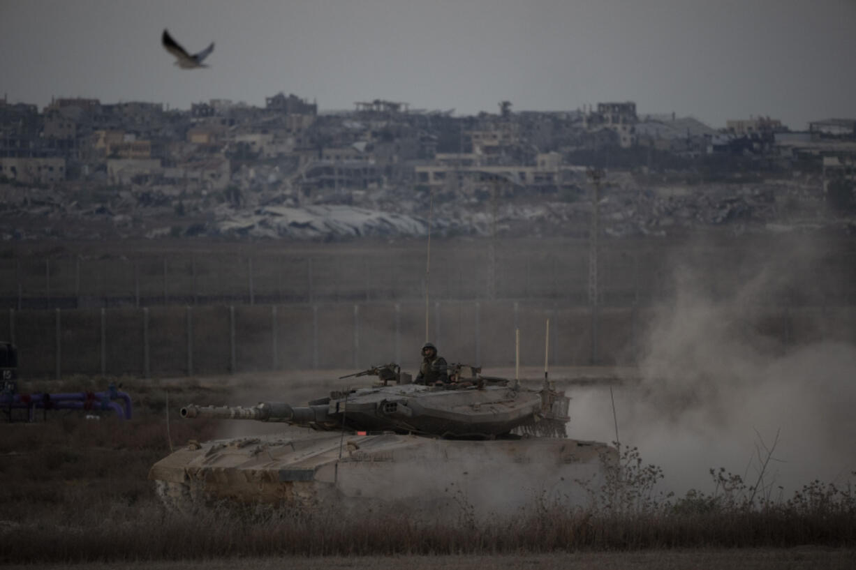 Israeli soldiers move on the top of a tank near the Israeli-Gaza border, as seen from southern Israel, Wednesday, Aug. 21, 2024.