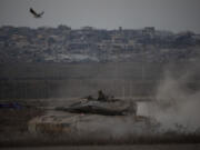 Israeli soldiers move on the top of a tank near the Israeli-Gaza border, as seen from southern Israel, Wednesday, Aug. 21, 2024.