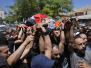 Mourners carry the bodies of Palestinians Wael Misha, 18, front and Ahmed Sheikh Khalil, 20, both killed by an airstrike overnight during an army operation in the occupied West Bank, during their funeral in the refugee Camp of Balata, in Nablus, Thursday, Aug. 15, 2024.