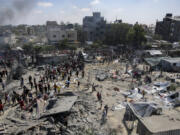 FILE -Palestinians inspect the damage at a site hit by an Israeli bombardment on Khan Younis, southern Gaza Strip, Saturday, July 13, 2024. Israel said it targeted Hamas&rsquo; shadowy military commander Mohammed Deif in a massive strike Saturday in the crowded southern Gaza Strip that killed at least 71 people, according to local health officials.