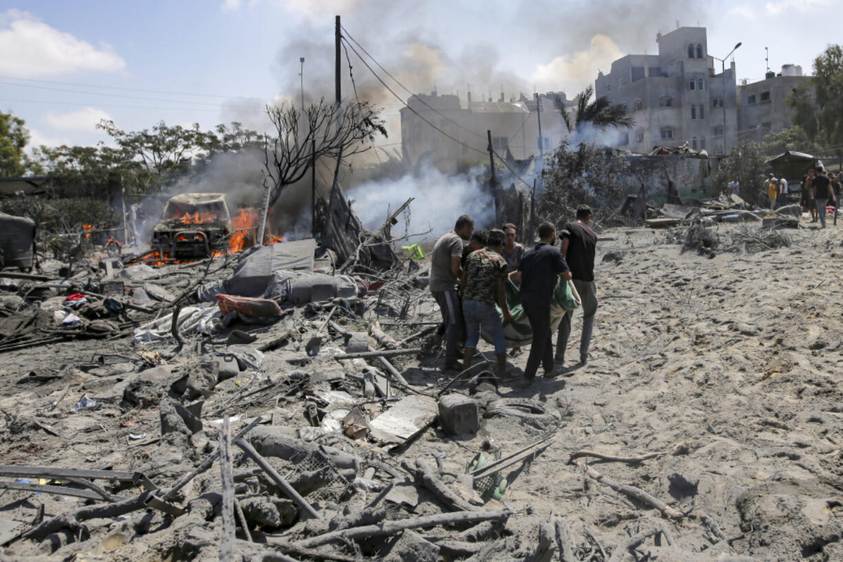 FILE - Palestinians evacuate a body from a site hit by an Israeli bombardment on Khan Younis, southern Gaza Strip, on July 13, 2024. Israel said it targeted Hamas&rsquo; military commander Mohammed Deif in a massive strike Saturday.