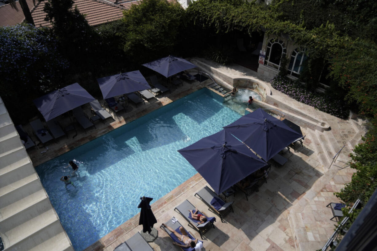 Guests swim and sunbathe at the pool at the American Colony Hotel in east Jerusalem, Sunday, Aug. 18, 2024. As Israel&rsquo;s economy is suffering from the nearly 11-month war with Hamas, Jerusalem&rsquo;s iconic American Colony hotel has had to lay off workers and are mulling pay cuts, said Jeremy Berkovitz, the official representative of the owners.