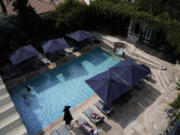 Guests swim and sunbathe at the pool at the American Colony Hotel in east Jerusalem, Sunday, Aug. 18, 2024. As Israel&rsquo;s economy is suffering from the nearly 11-month war with Hamas, Jerusalem&rsquo;s iconic American Colony hotel has had to lay off workers and are mulling pay cuts, said Jeremy Berkovitz, the official representative of the owners.