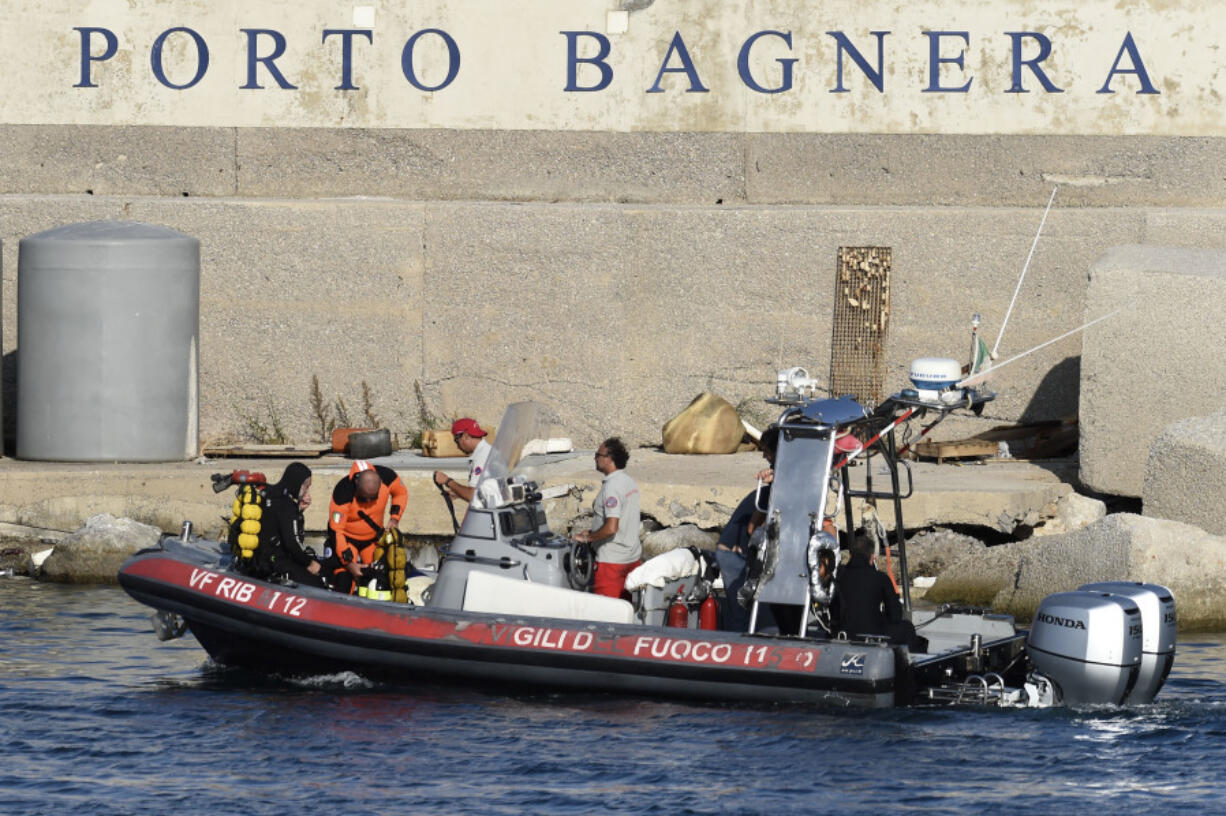 Scuba divers arrive at the harbor of Porticello, southern Italy, Tuesday, Aug. 20, 2024. Rescue teams and divers returned to the site of a storm-sunken superyacht Tuesday to search for six people, including British tech magnate Mike Lynch, who are believed to be still trapped in the hull 50 meters (164-feet) underwater.