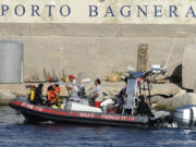 Scuba divers arrive at the harbor of Porticello, southern Italy, Tuesday, Aug. 20, 2024. Rescue teams and divers returned to the site of a storm-sunken superyacht Tuesday to search for six people, including British tech magnate Mike Lynch, who are believed to be still trapped in the hull 50 meters (164-feet) underwater.