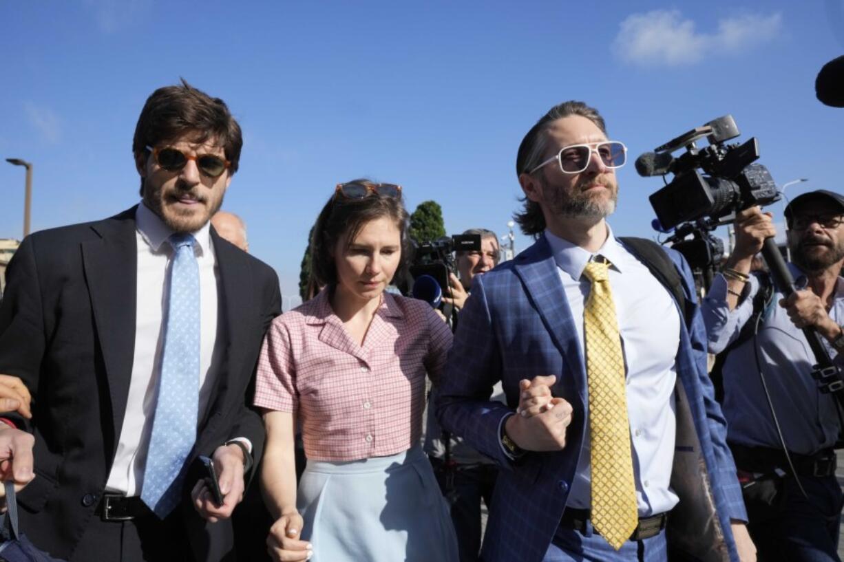 FILE - Amanda Knox arrives flanked by her husband, Christopher Robinson, right, and her lawyer, Luca Luparia Donati, left, at a court in Florence, Italy, June 5, 2024.