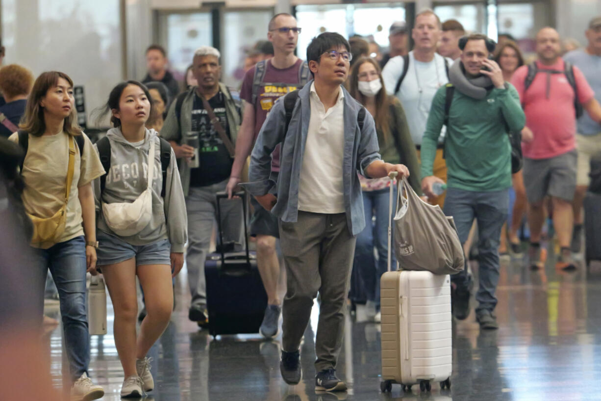 FILE - Travelers pass through Salt Lake City International Airport on July 3, 2024, in Salt Lake City.